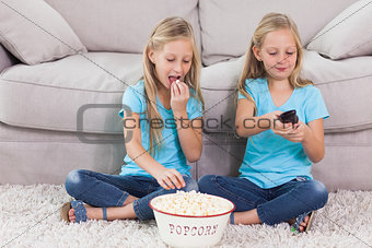 Twins eating popcorn and watching television