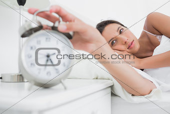 Woman turning off the alarm clock in the morning