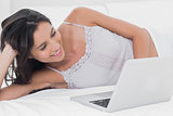 Woman using her laptop in bed