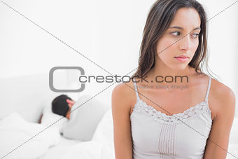 Worried woman sitting in bed
