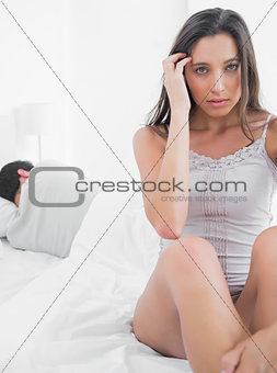 Woman feeling worried sitting in bed