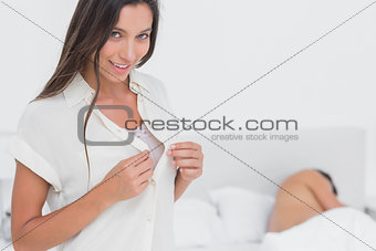 Woman sneaking out of bed