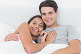 Woman embracing her boyfriend in bed