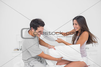 Couple having fun with a pillow fight