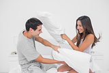Couple fighting together with pillows