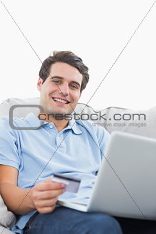 Portrait of a man using his credit card to buy online