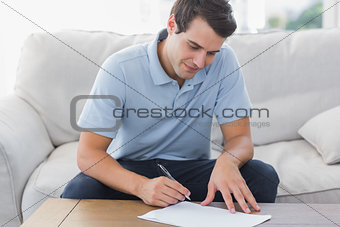 Handsome man writing on a paper