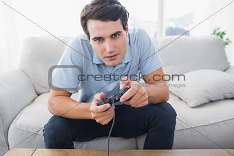 Man playing video games while he is sat on a sofa