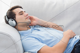 Man enjoying music lying on a couch