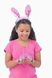 Little girl wearing rabbit ears and holding spring