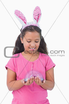 Little girl wearing rabbit ears and holding spring