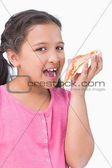 Smiling little girl eating pizza