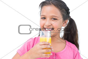 Smiling little girl drinking orange juice