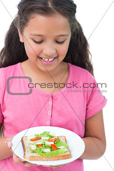 Little girl looking at her sandwich
