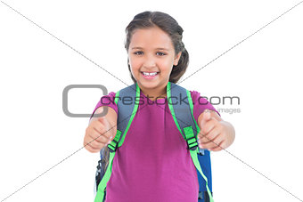 Smiling little girl with book bag does thumbs up at camera