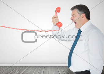 Businessman holding a phone and screaming