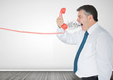 Mature businessman screaming on the phone