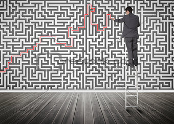 Businessman standing on a ladder solving maze puzzle