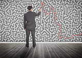 Businessman tracing a red line on a maze