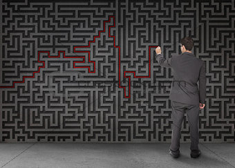 Rear view of a businessman drawing a red line through black maze