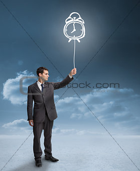 Businessman holding a floating alarm clock