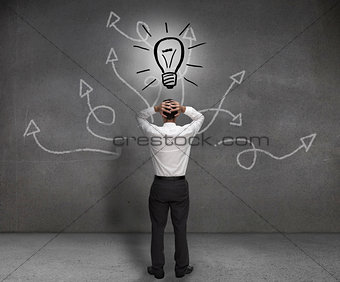 Stressed businessman looking at a light bulb