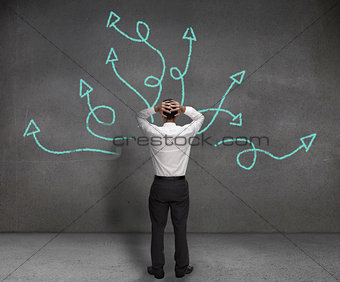 Stressed businessman looking at arrows