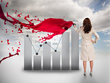 Creative businesswoman drawing a chart next to red paint splash