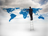 Businessman standing on a ladder drawing a world map