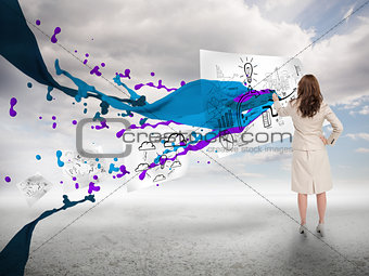 Businesswoman drawing on a paper next to paint splash
