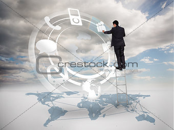 Businessman on a ladder selecting an icon on a hologram