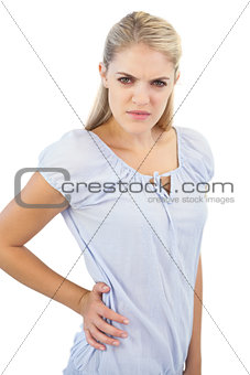 Unsmiling blonde woman has pain in lower back
