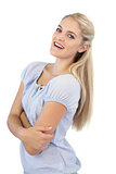 Happy young blonde woman with crossed arms