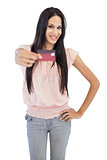 Smiling brunette showing her credit card to camera