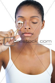 Young woman using curler for her eyelash