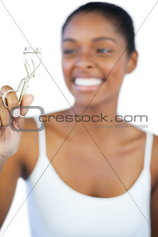 Laughing woman looking at her eyelash curler