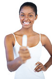 Young woman showing her lip balm to camera