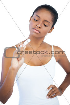 Serious woman with her hand on hip looking at lip balm