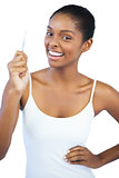 Smiling woman with her hand on hip holding tweezers