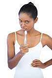 Woman pointing at camera with her toothbrush