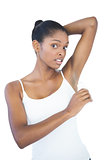 Woman putting deodorant on her armpit