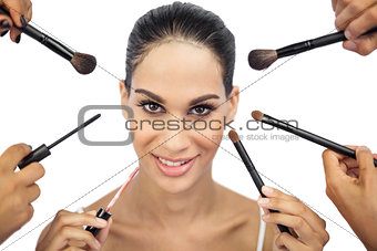 Beautiful woman encircled by make up brushes