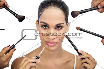 Glamorous woman encircled by make up brushes