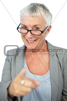 Woman with glasses pointing at camera