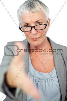 Serious woman with glasses presenting her hand for handshake