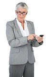 Businesswoman with glasses using her mobile phone