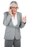 Excited businesswoman calling someone with her mobile phone
