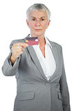 Serious businesswoman showing her credit card
