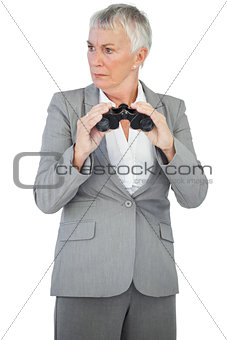Unsmiling businesswoman holding binoculars