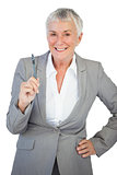 Businesswoman with hand on hip holding pen